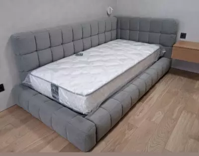 Кровать угловая с мягкими спинками.