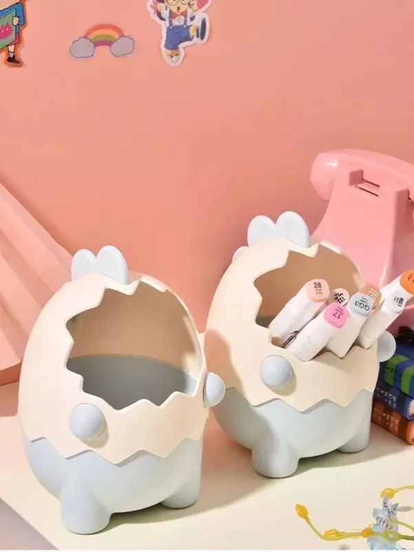 Органайзер в виде мультяшного динозавра в яичной скорлупе.